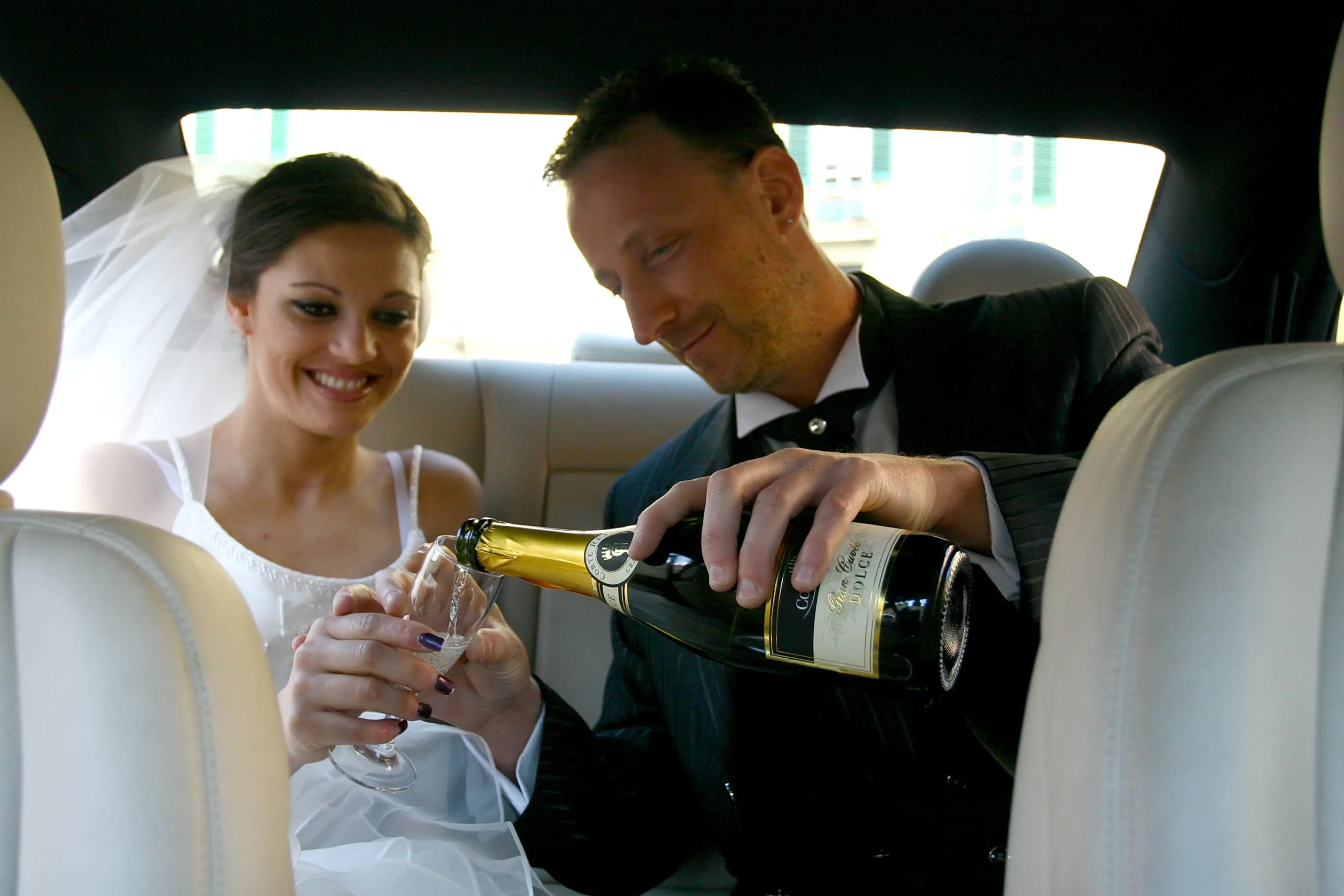 sposi dentro auto noleggio al matrimonio